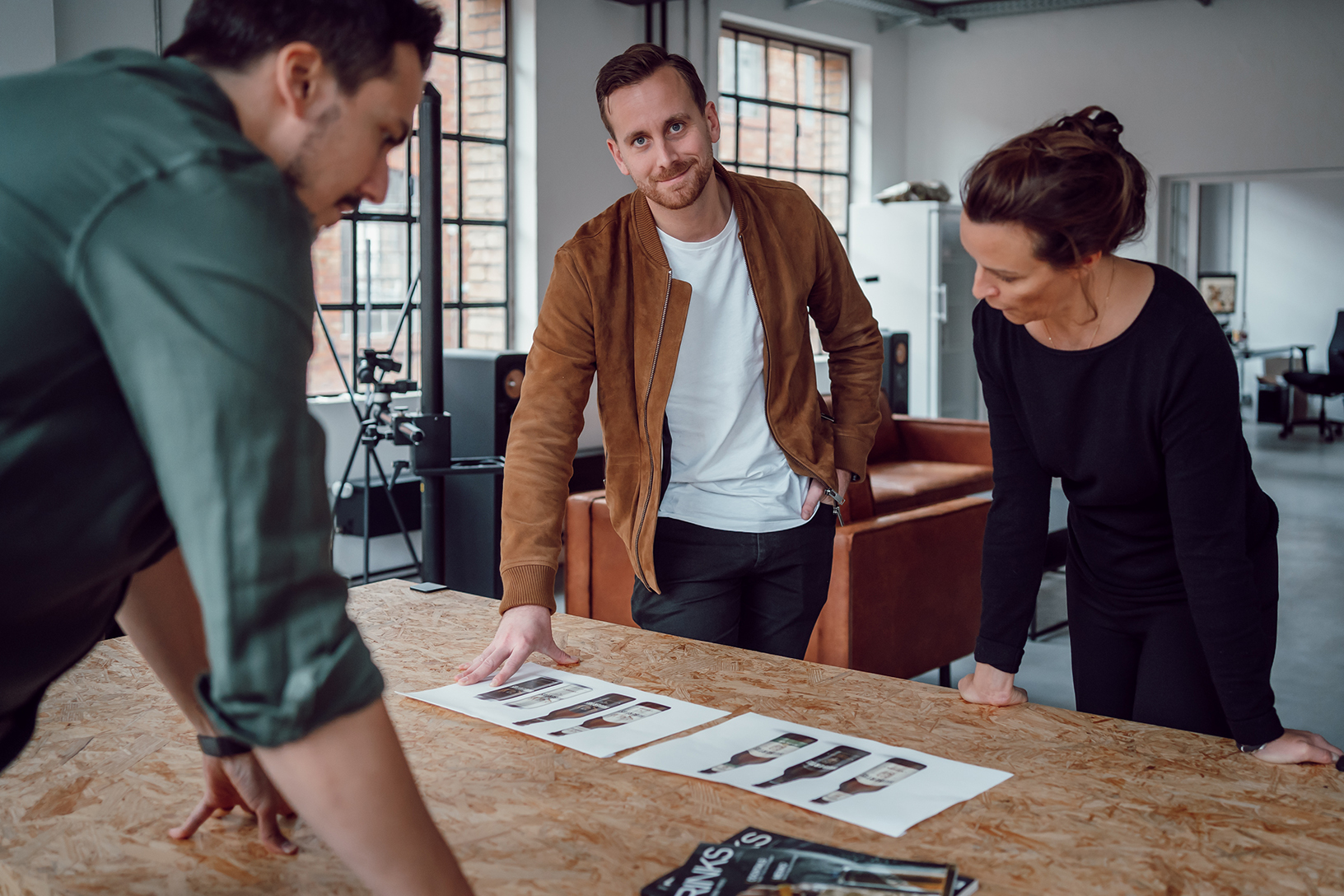 Die Geschäftsführer Max Wenzel, Paul Valentiner und Nadine Hartmann begutachten Designlayouts